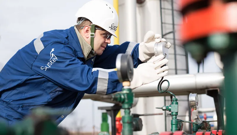 Systel engineer inspecting a gauge on a compressed-air line