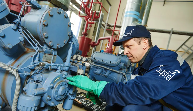Systel technician checking a reciprocating compressor