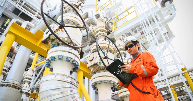 Systel engineer reading live data on a tablet beside plant valves